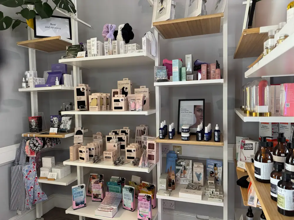 Shelves stocked with various beauty and skincare products, including boxes, bottles, and pouches, arranged neatly in a shop display.